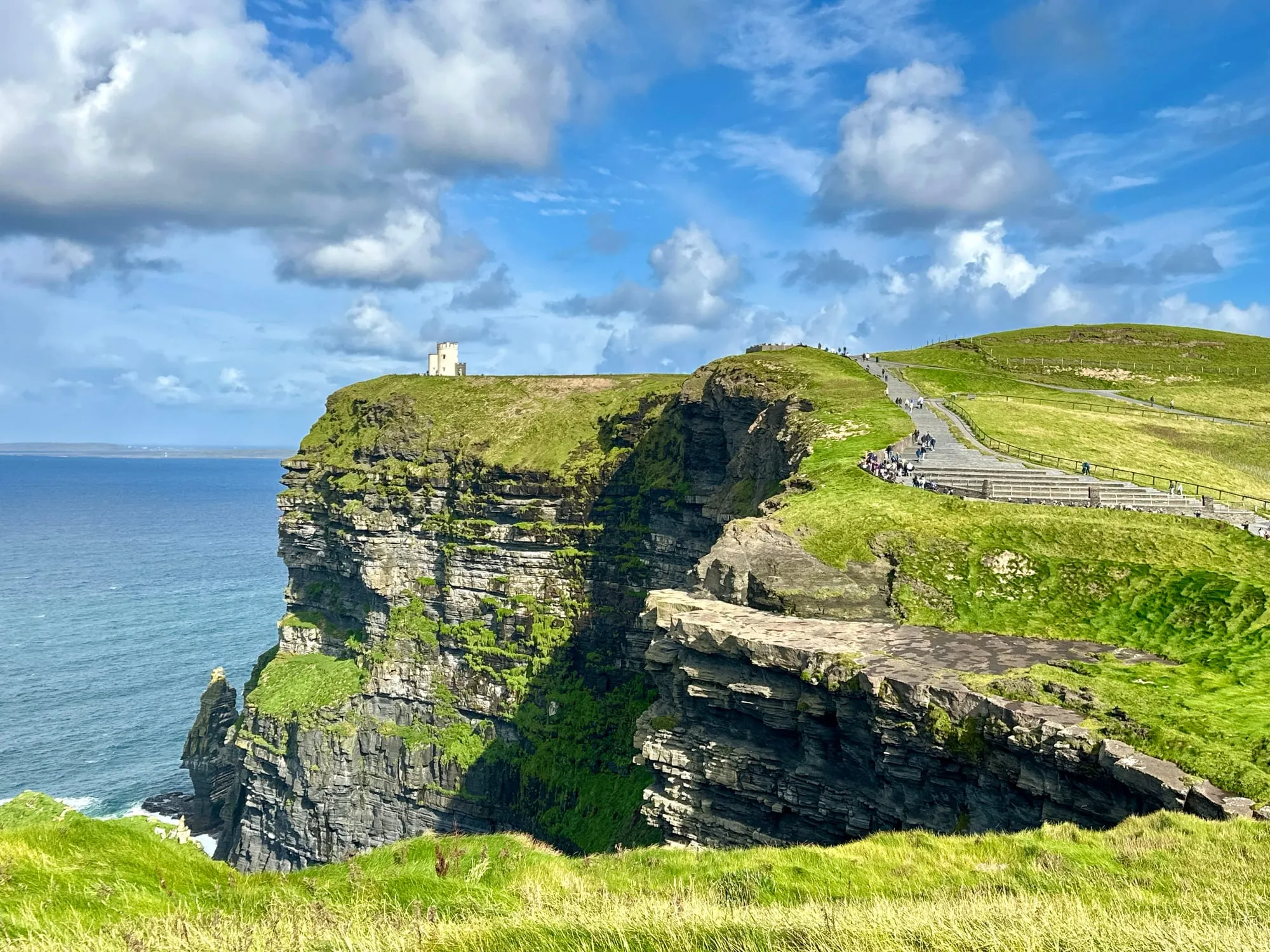 O'Brien's Tower auf der Klippenkante der Cliffs of Moher, rechts der befestigte Besucherweg mit Treppenstufen.