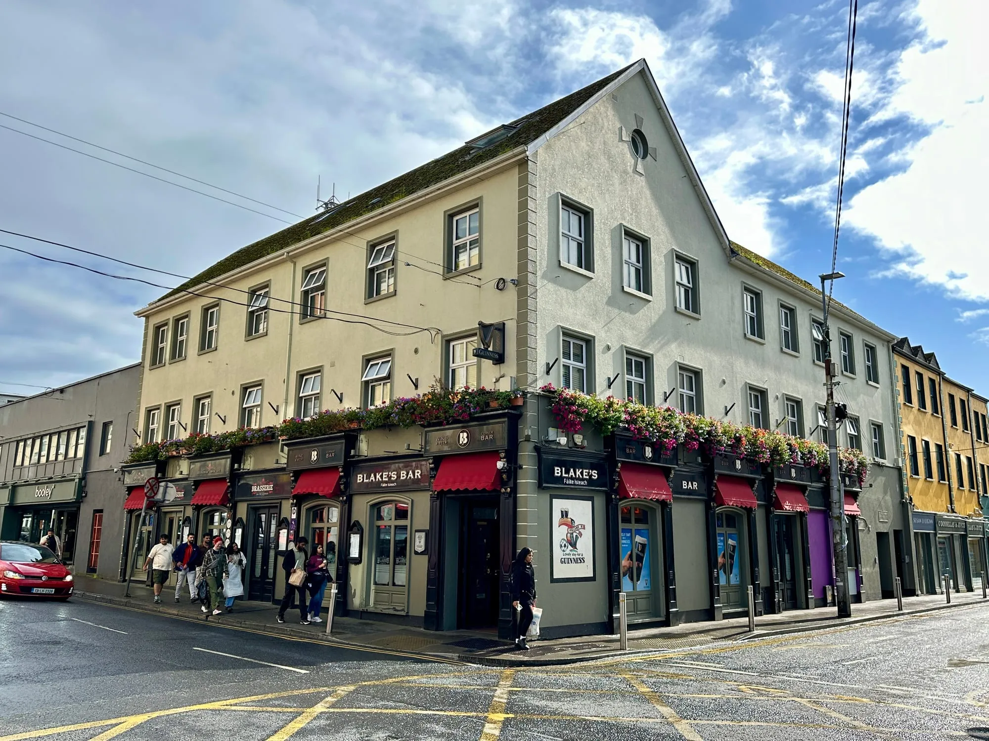 Eckhaus mit dem Pub Blake's Bar in Galway, die Fassade dicht mit Blumenkästen bepflanzt.