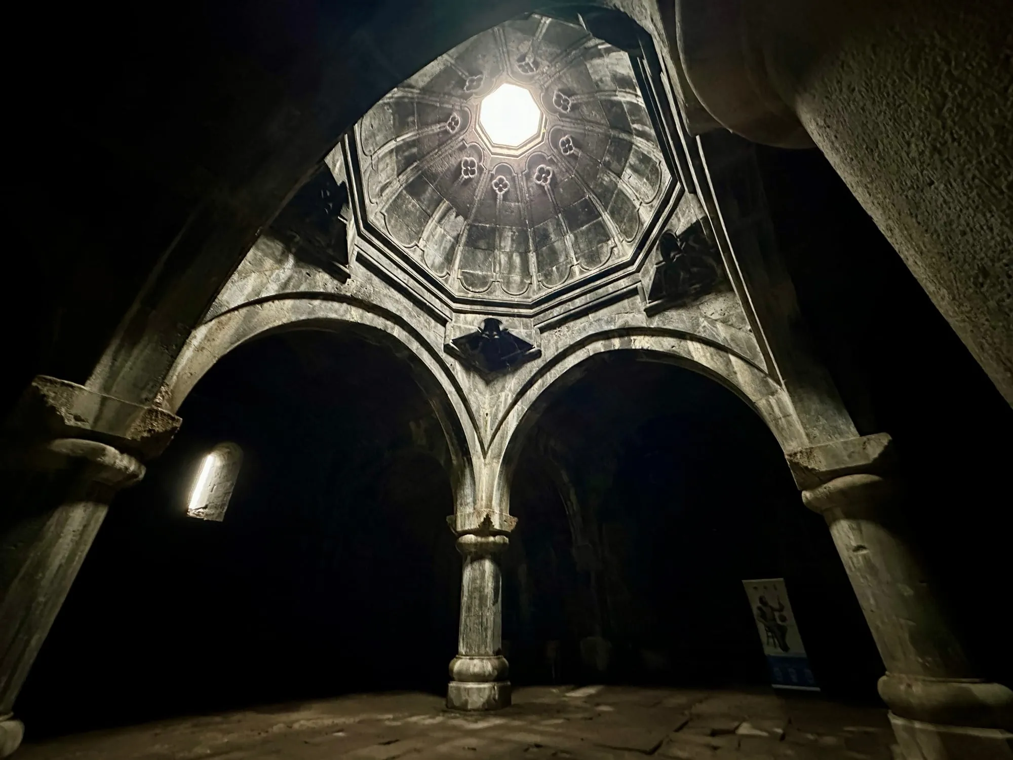 Steinernes Gewölbe des Gawits im Kloster Haghpat mit Rundbögen, Steinornamenten und einem hellen achteckigen Oberlicht.