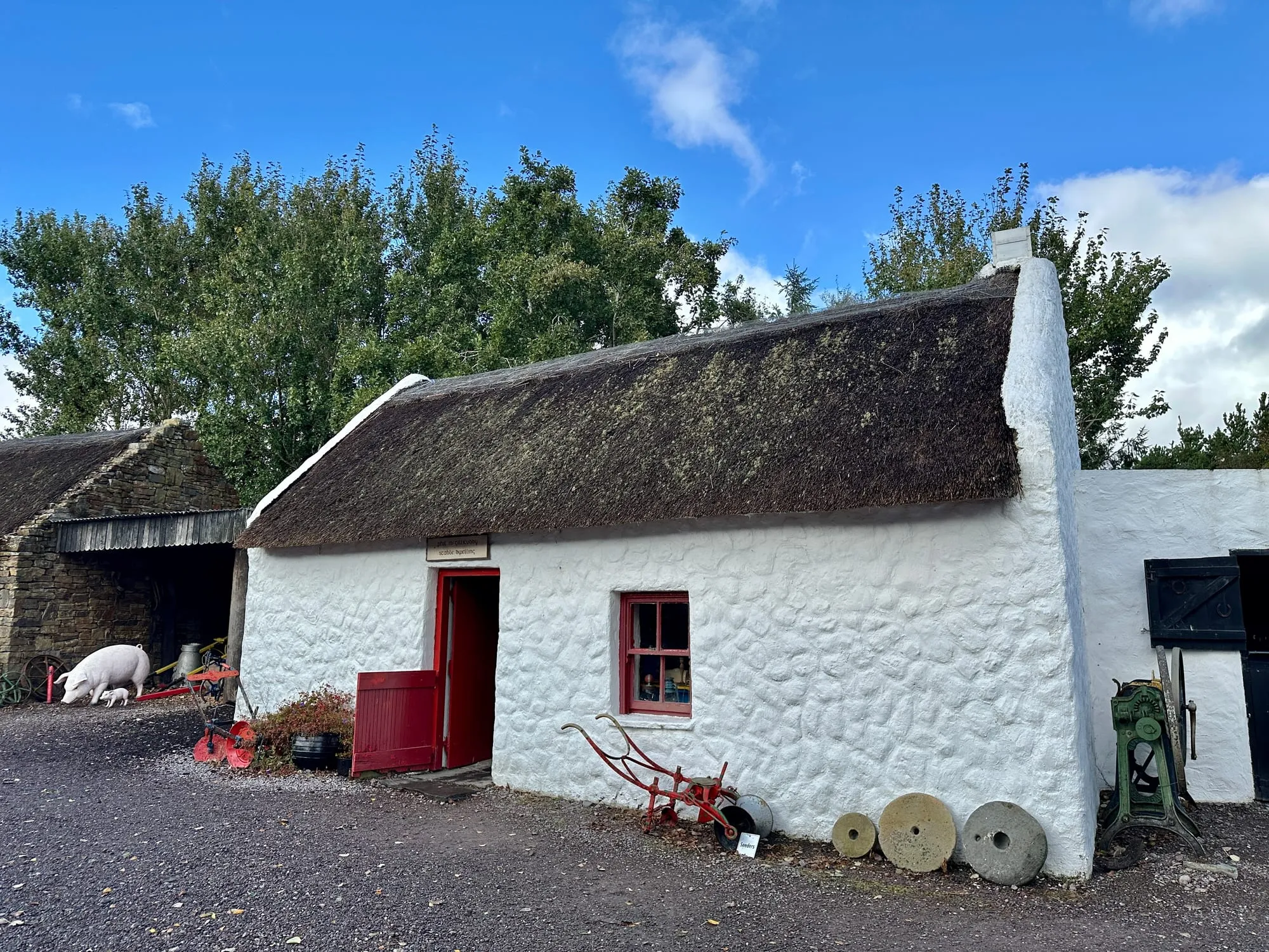 Weiss gekalkte Torfstecherkate mit Reetdach und roter Tür im Kerry Bog Village Museum.