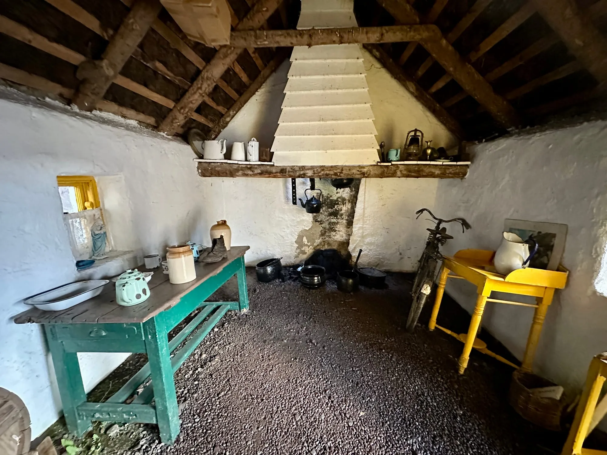 Innenraum einer Torfstecherkate im Kerry Bog Village mit offener Feuerstelle.