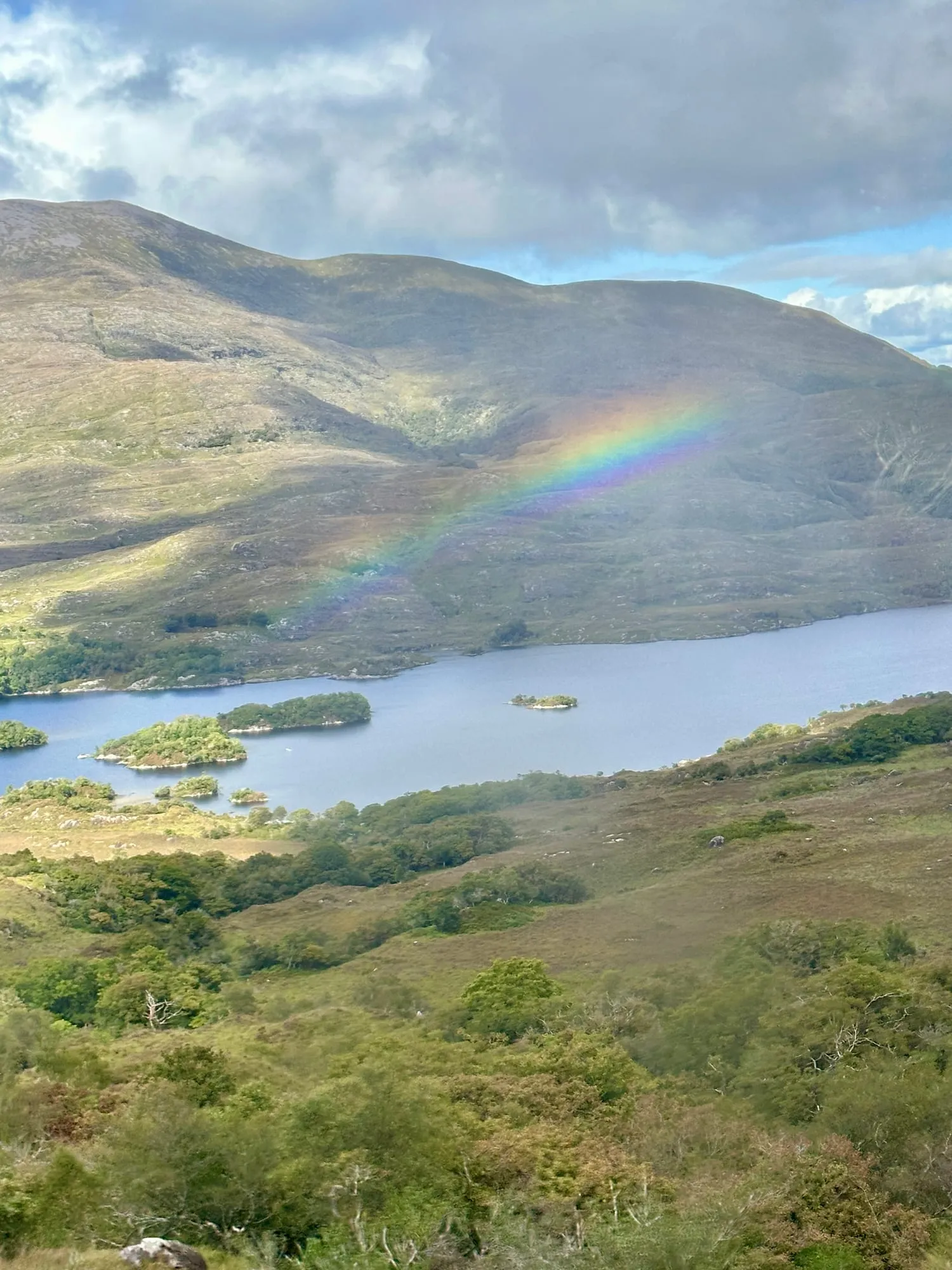 Blick vom Aussichtspunkt Ladies View über die Seen des Killarney-Nationalparks, darüber ein Regenbogen.