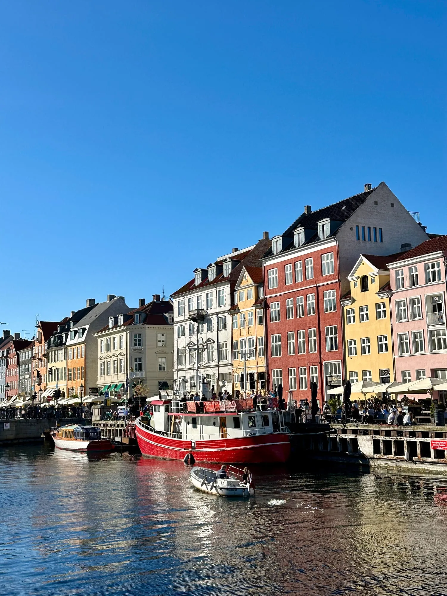 Bunte Giebelhäuser und Holzboote am Kanal von Nyhavn in Kopenhagen.