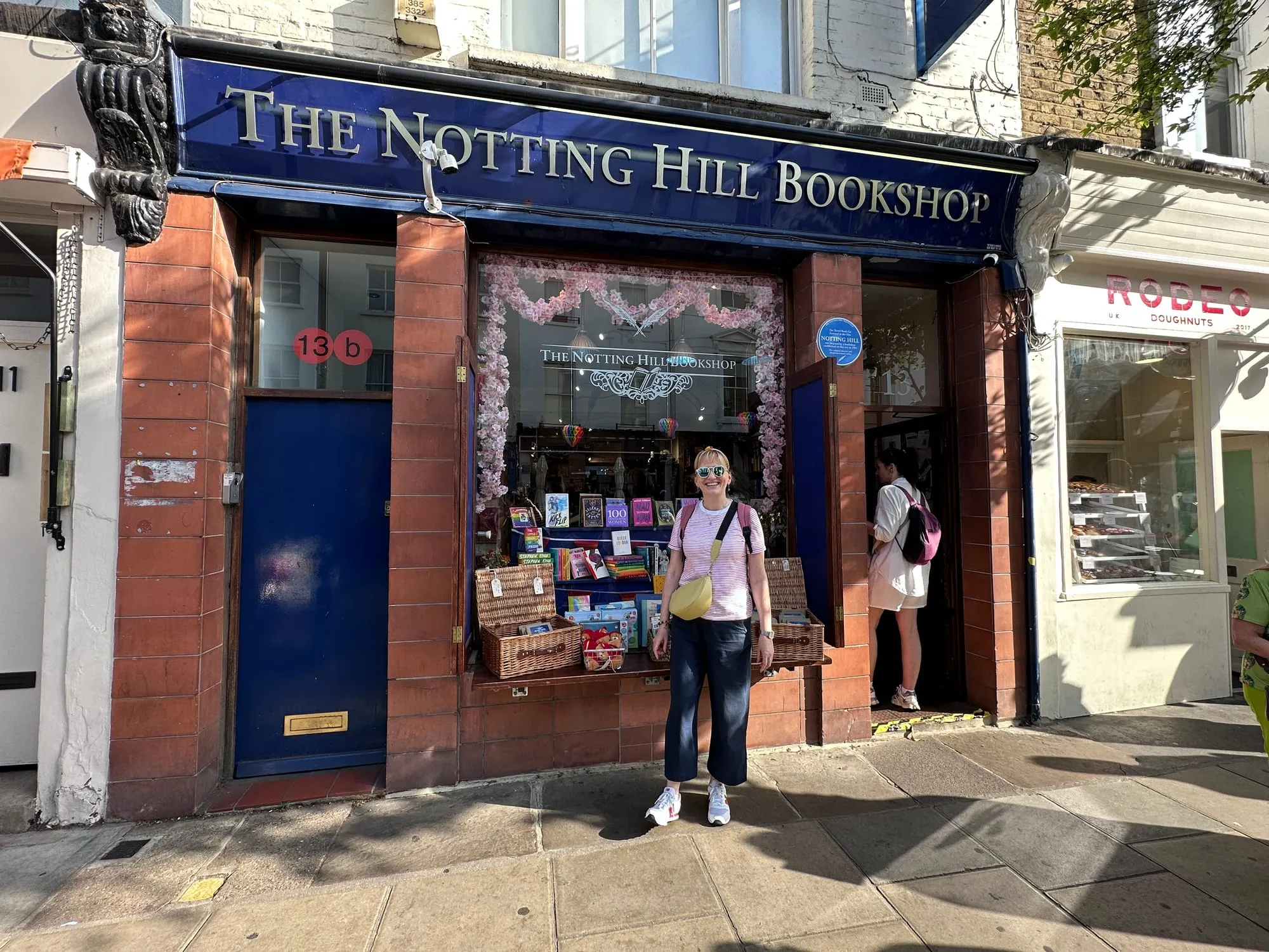 Blaue Fassade des Notting Hill Bookshop mit Büchertischen vor dem Schaufenster.