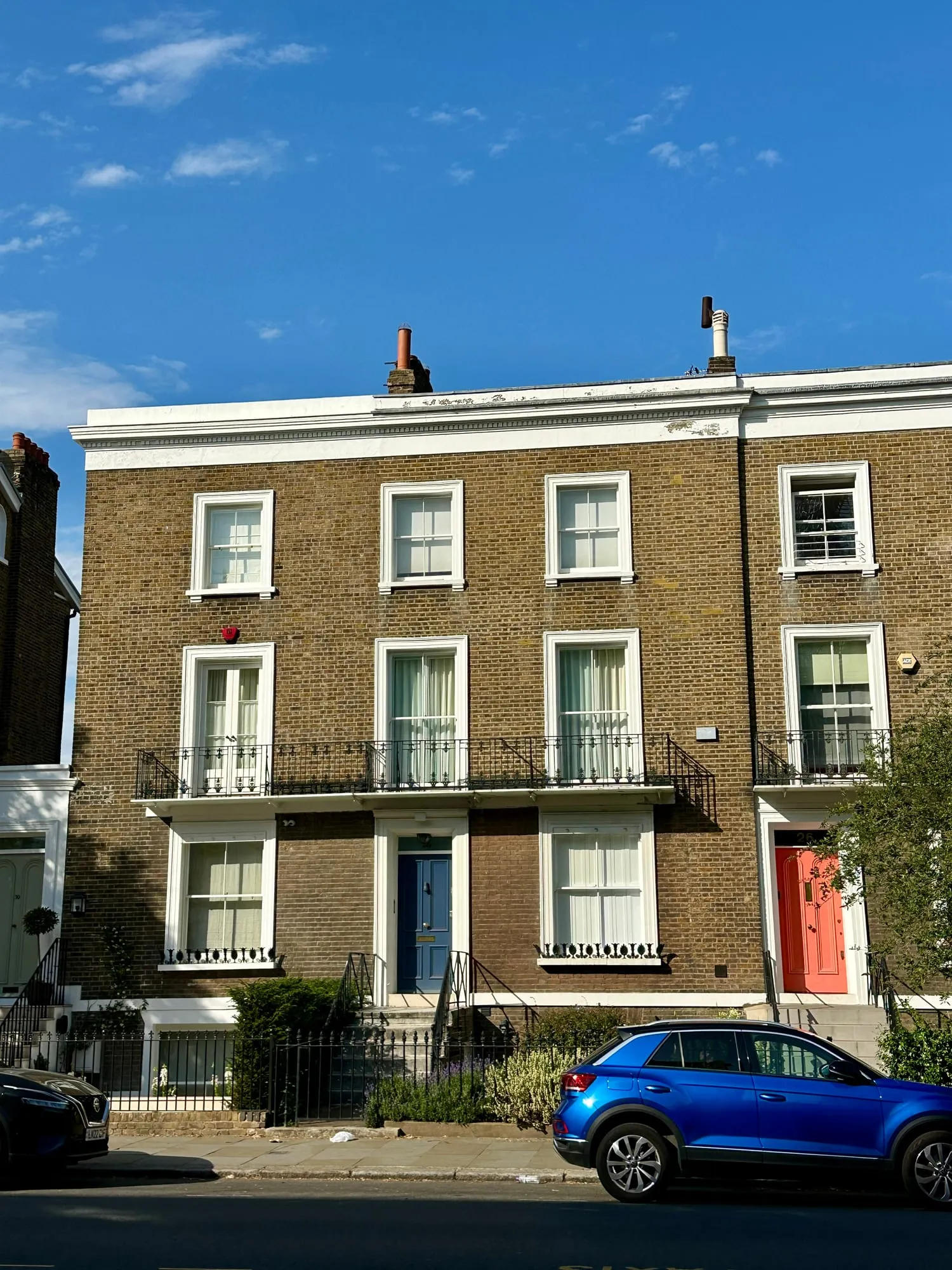 Backsteinhäuser in Notting Hill mit Sprossenfenstern und farbigen Haustüren.