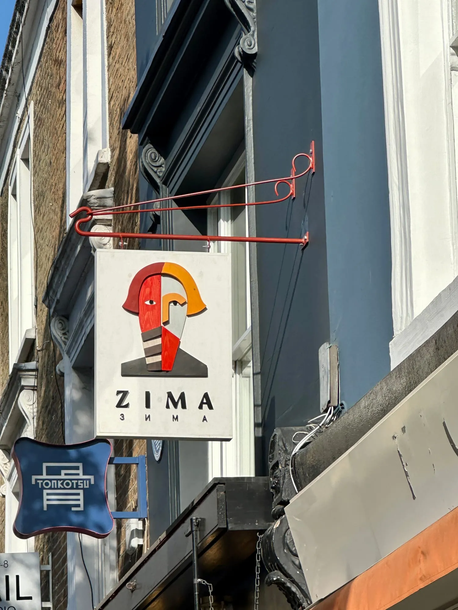 Ausleger-Schilder eines russischen und eines japanischen Restaurants an einer Hausfassade in Soho.