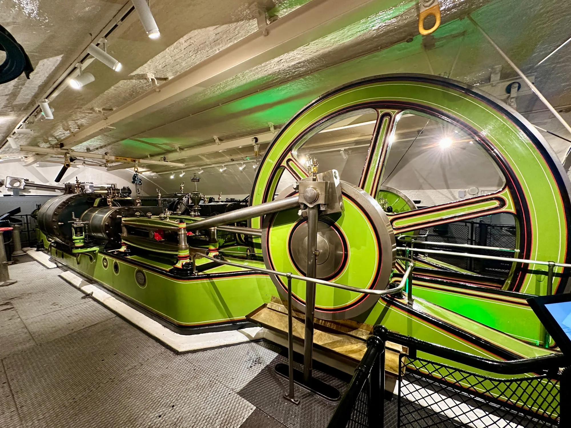 Grün lackierte viktorianische Dampfmaschine mit grossem Schwungrad im Maschinenraum der Tower Bridge.
