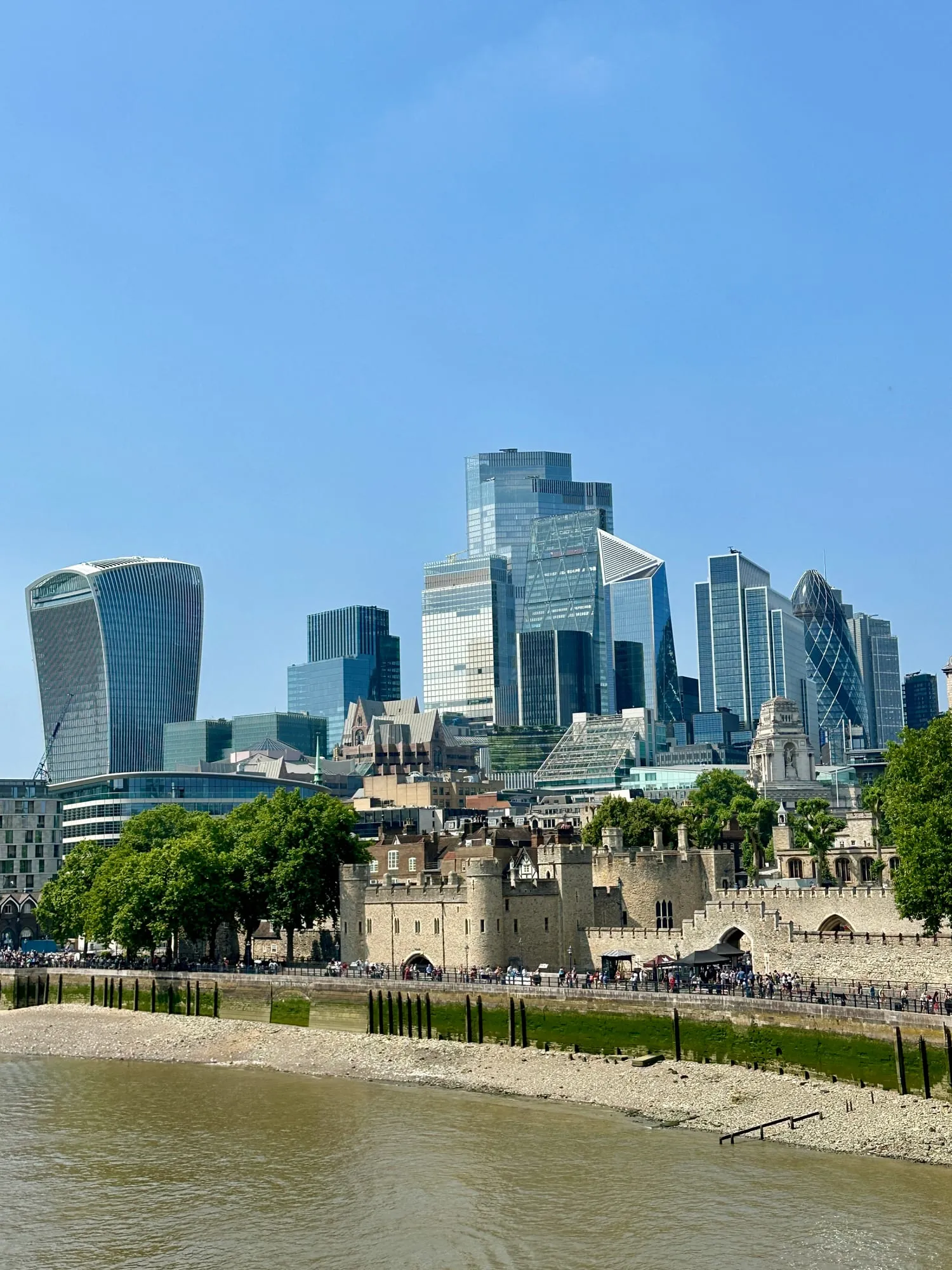 Mauern und Türme des Tower of London vor den Hochhäusern der City mit Walkie Talkie und Gherkin.