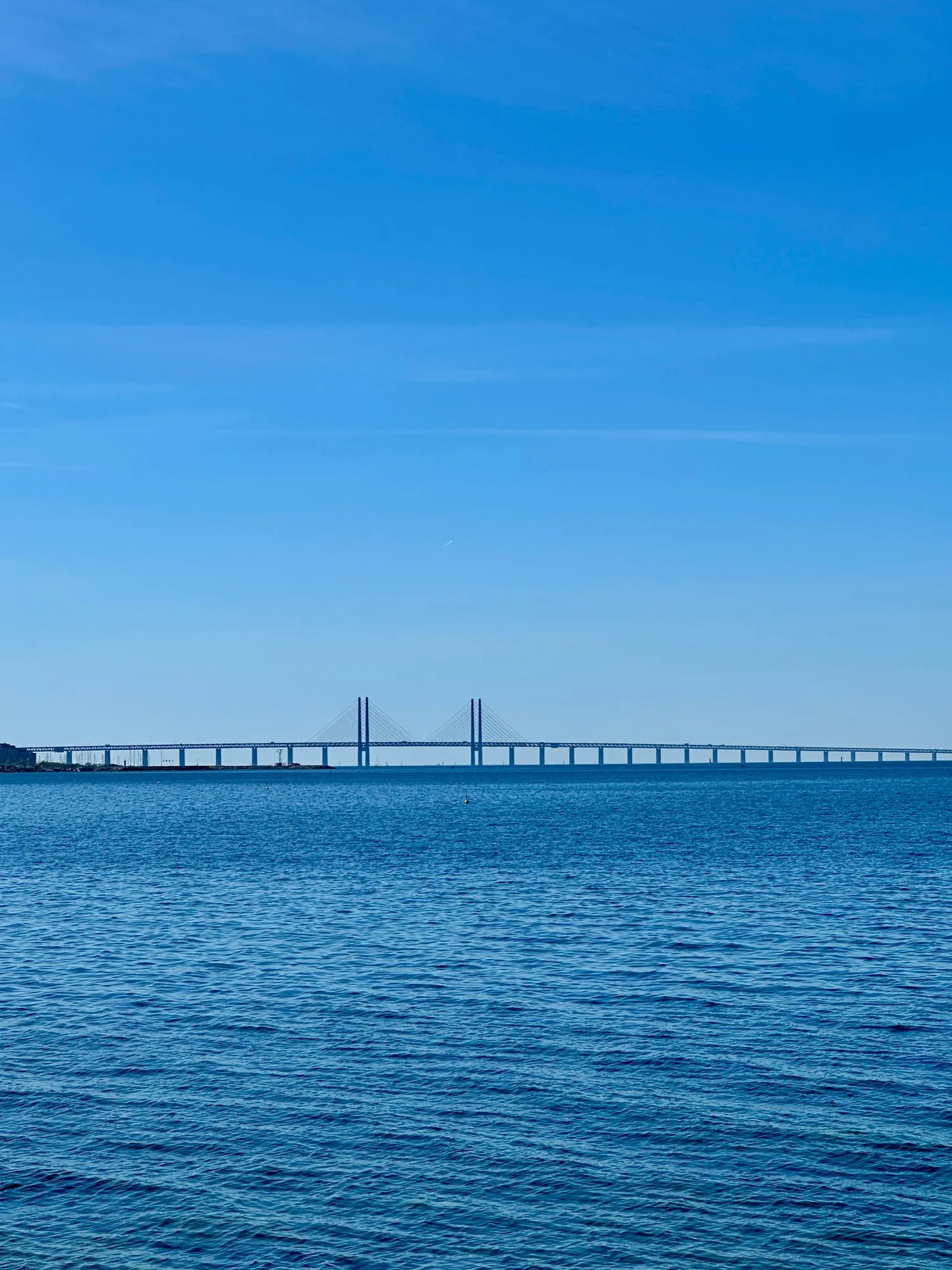 Die Öresundbrücke am Horizont vom Strand Ribersborg in Malmö aus gesehen.