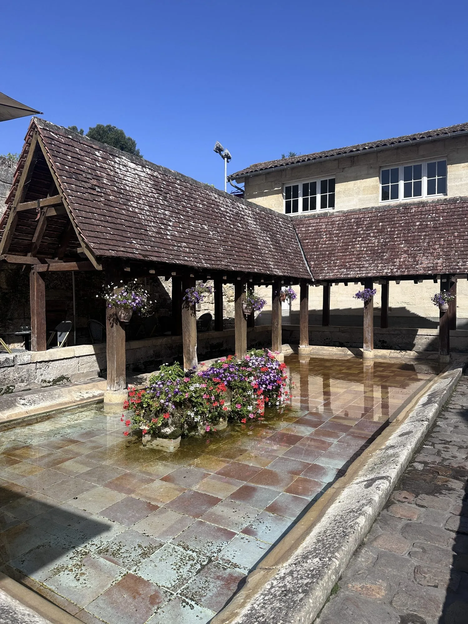 Alter gedeckter Waschplatz mit Blumenschmuck in Saint-Émilion