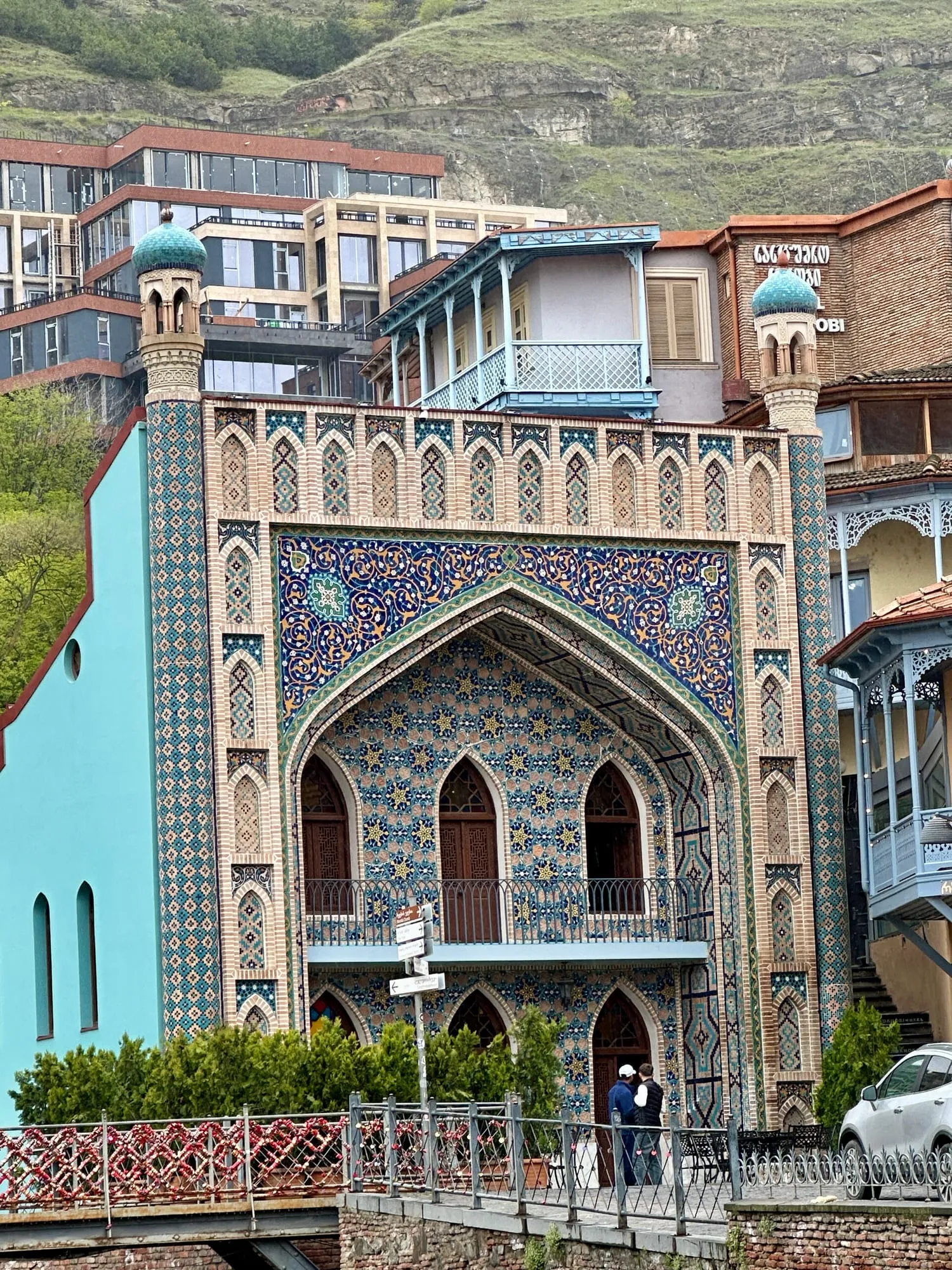 Blau-türkise, reich verzierte Fassade des Schwefelbads Chreli Abano in Tbilisi mit Spitzbögen, zwei kleinen Kuppeln und georgischer Beschriftung.
