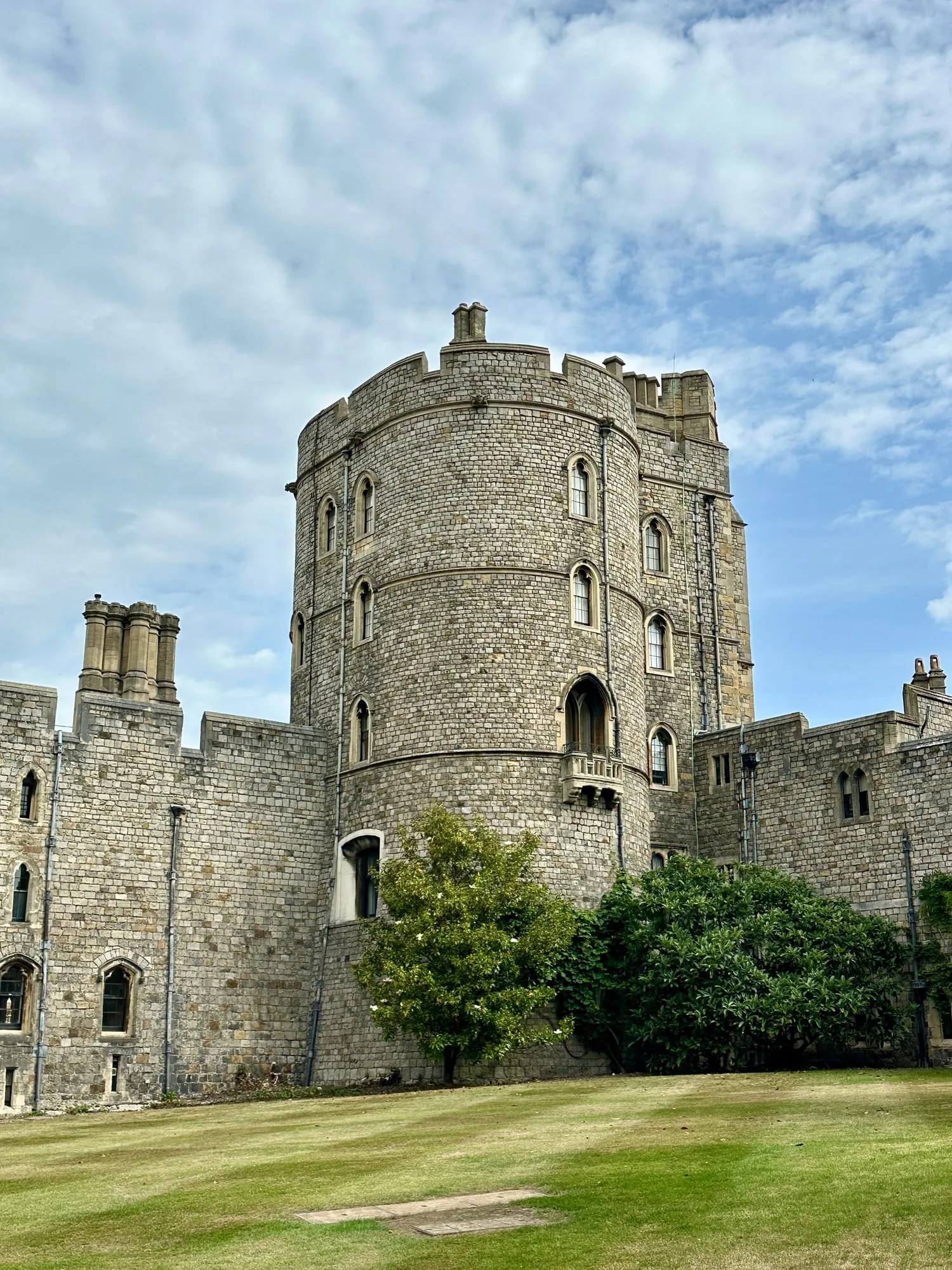 Runder Wehrturm in der Ringmauer von Windsor Castle, davor eine Rasenfläche.