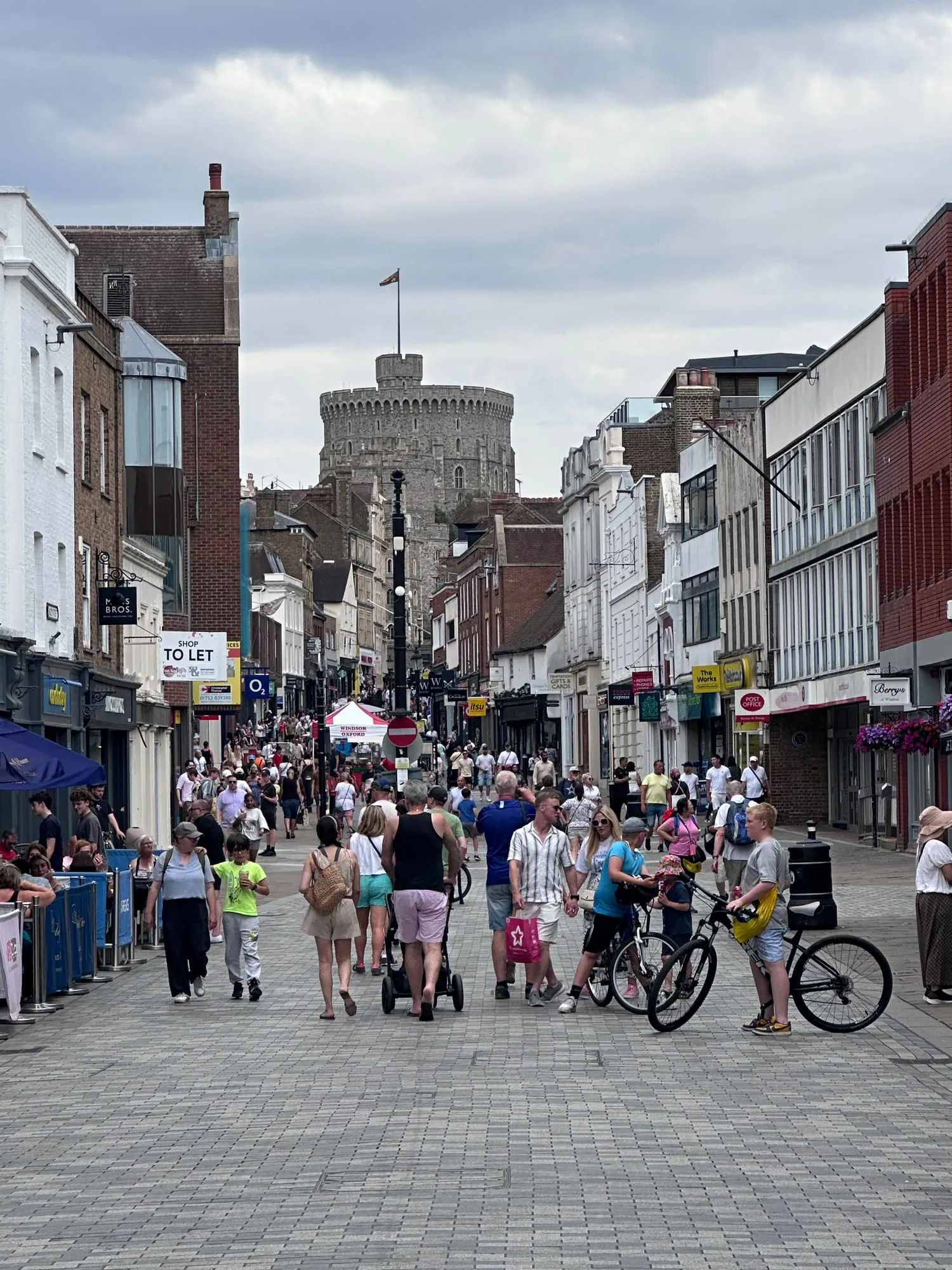 Einkaufsstrasse in Windsor mit Passanten und dem Round Tower über den Dächern.